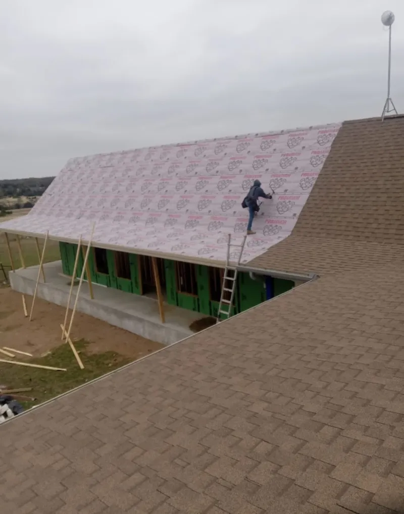 Worker preparing underlayment for a metal roof installation in Park Forest